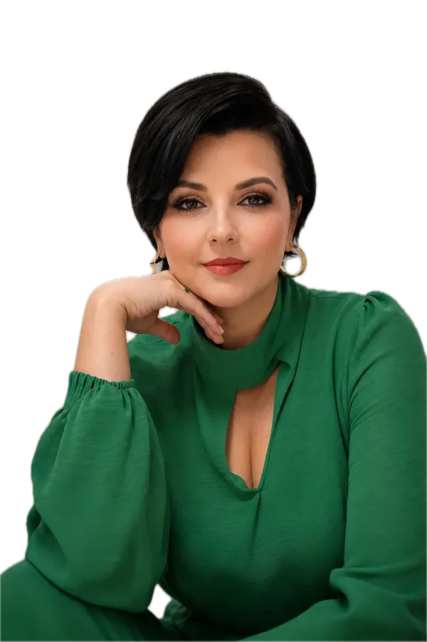 Retrato de Daphine Santana, psicomotricista, de blusa verde, sorrindo com a mão no queixo